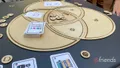 Overhead view of the round wooden EDGY game board on a table, with a deck of "EDGY Enterprise Design Graphical Language" cards and wooden tokens.