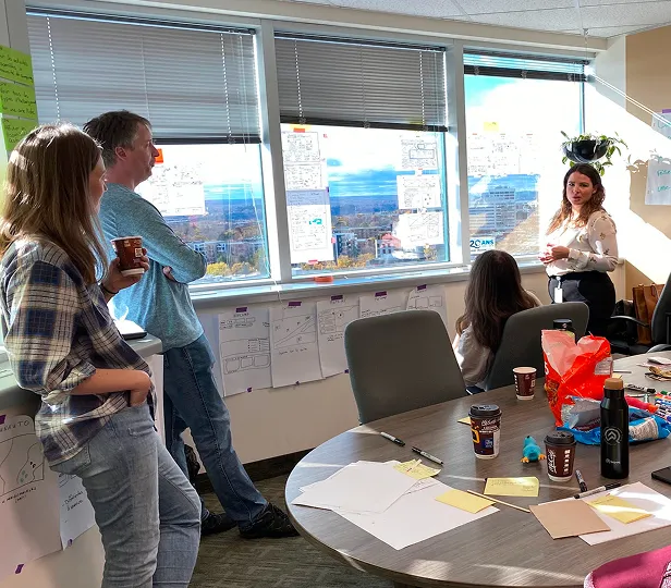 Workshop discussion around sticky notes on a wall